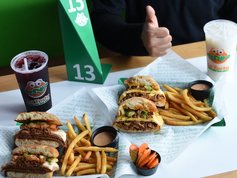 Tortas servidas en su papel con papas fritas y salsa chipotle